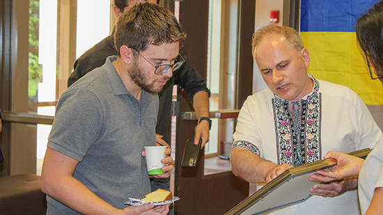"Dr.  Panchenko in discussion with an FSU student as they look at a book."