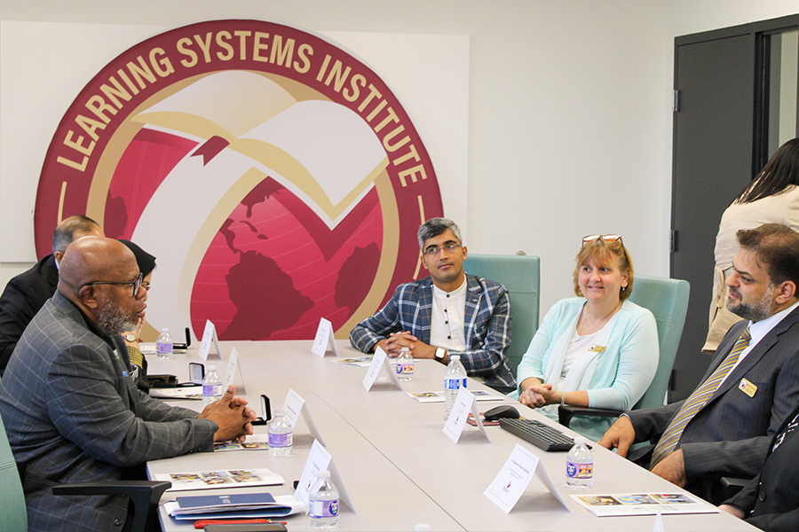 "LSI Director Rabieh Razzouk sitting at a conference table with United Nations General Assembly President Dennis Francis and other staff members,"