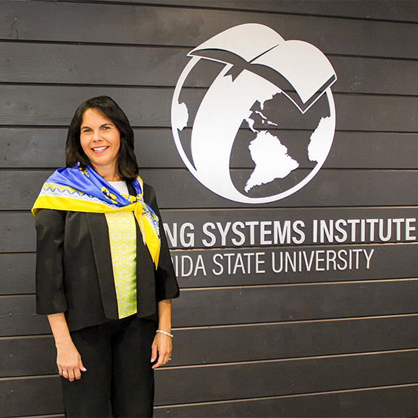 Photo of Dr. Vilma Fuentes standing next to an LSI wall logo.