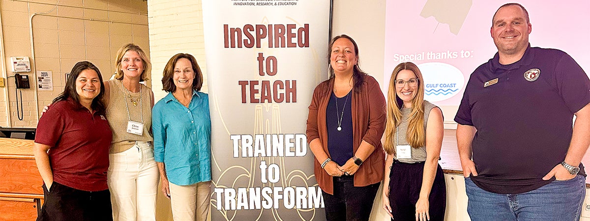 Anna Prindle poses for a group photo in front of an FSU InSPIRE banner with fellow STEM facilitators.
