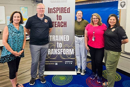 Group photo taken in front of an InSPIRE stand-up banner.