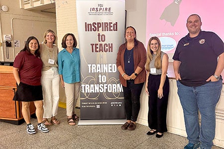 Group photo taken in front of an InSPIRE stand-up banner.