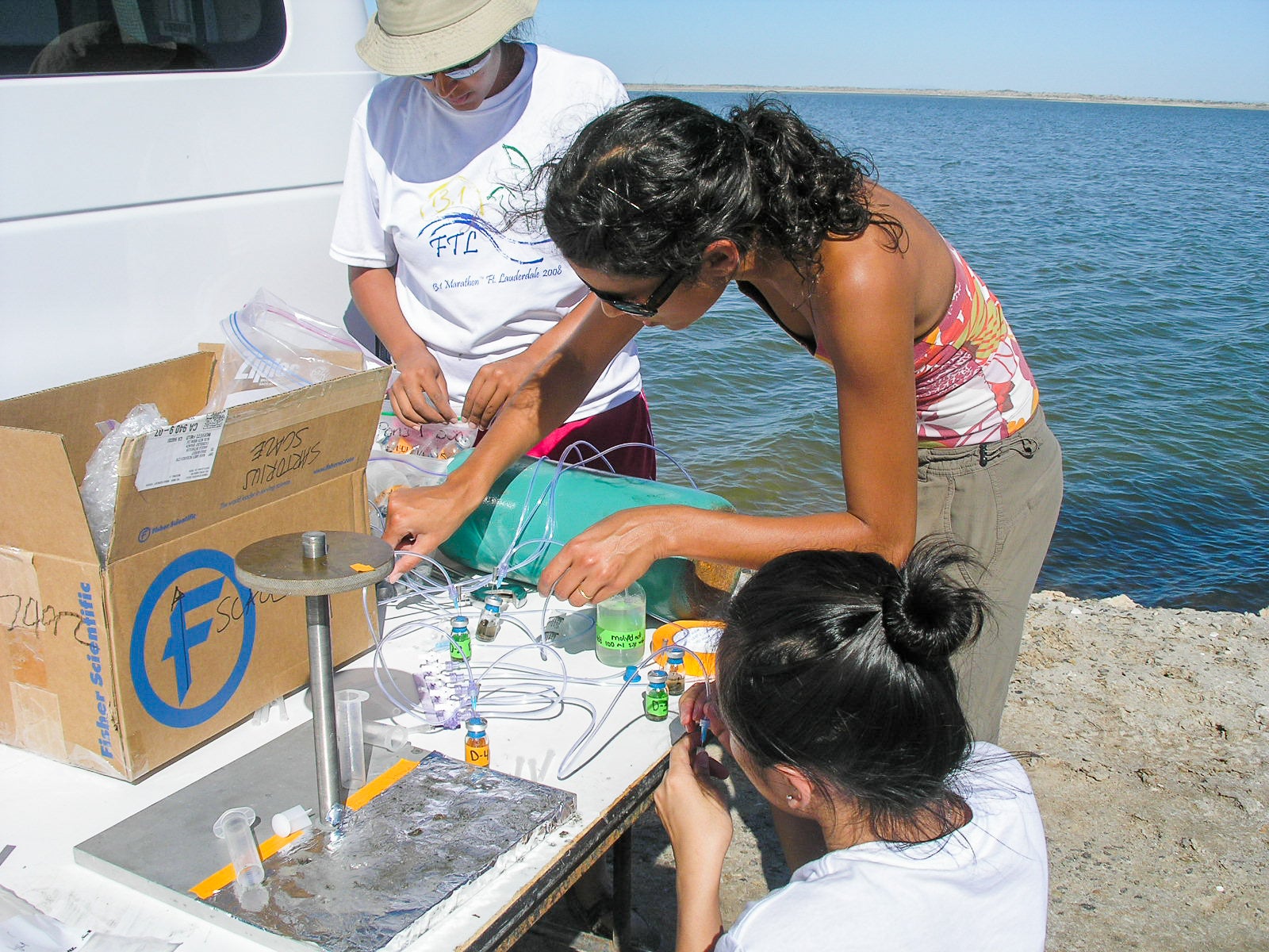 A group of young students are conducting scientifi test on a beach.