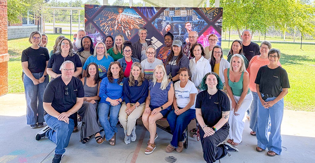 Group photo of workshop participants infront of a large banner.