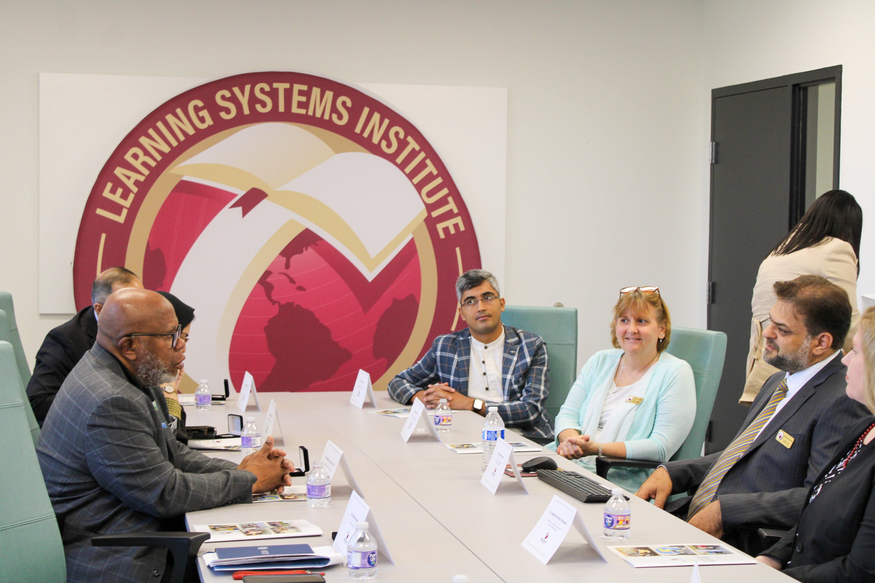Gena St. John in a conference room meeting with a group including the UN President of the General Assembly. 