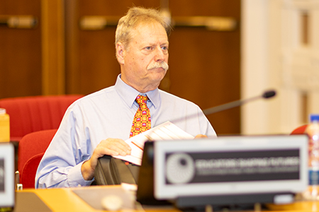 Steve McDowell at a desk at Educators Shaping Futures conference. 