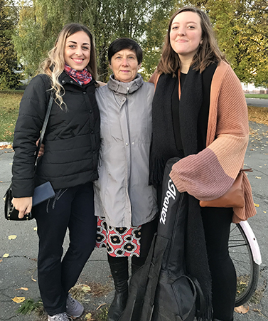 "Photo of three people with their arms around each other."