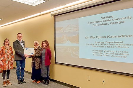 Dr. Ely being presented a certificate at Columbus State University.