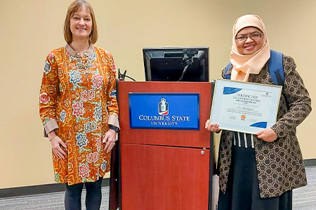 Dr. Ely being presented a certificate at Columbus State University.