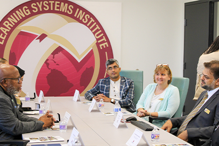 "President of the United Nations General Assembly, Mr. Dennis Francis sitting at a conference table in a meeting with LSI staff."