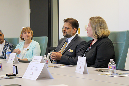 "Gena St. John, Rabieh Razzouk, and Dr. Stephanie Zuilkowski at a conference table"