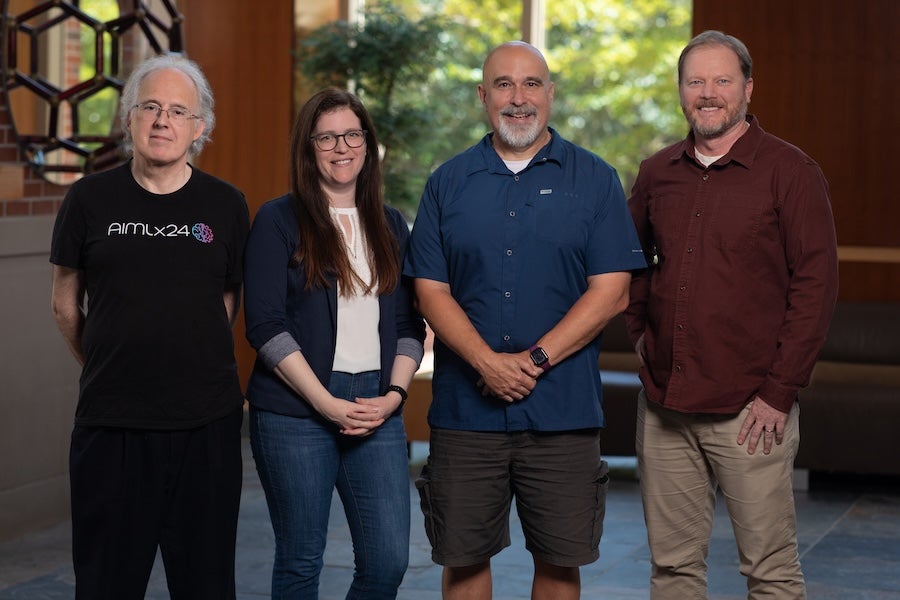 Group photo of four FSU researchers posing in the lobby of an FSU building.