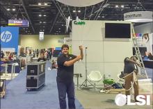 LSI Director Rabieh Razzouk holding a large balloon with the CPALMS logo on it inside an exhibition hall.