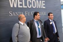 Three men in front of a Santa Fe College sign