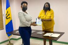 Two women pose holding a book