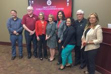 Group photo in front of a screen at the Turnbull Conference Center at FSU