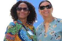 Two women pose for a photo in front of a Santa Fe College sign