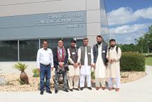 Small group posing in front of the Charles R. Perry Construction Institute