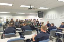 CCAP Indonesia group members standing in the front of a classroom all wearing baseball caps