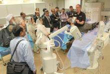 CCAP Pakistan listening to a presentation in a room with medical devices