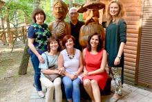Small group surrounding two hand-carved wooden statues