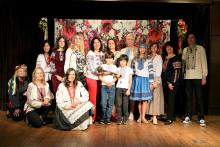 A group of guests in groups in Ukrainian Vyshyvankas poses for a photo at a celebration on the FSU campus.