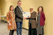 Dr. Ely Djulia Katmadihardja receiving a certificate from three representatives from Columbus State University.