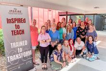 Group photo of participants in the FSU InSPIRE summer teacher workshops posing next to a stand-up banner. 