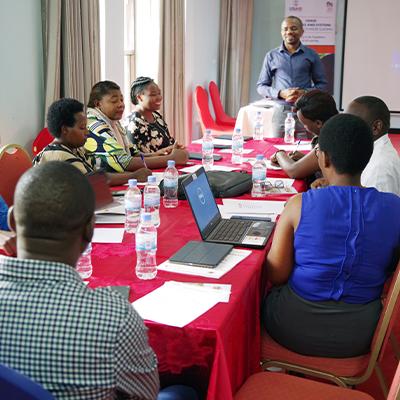 Group sitting at a table with laptops as part of the USAID Tunoze Gusoma (Schools and Systems) Activity