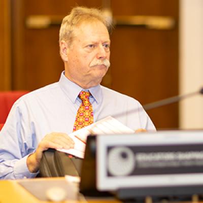 Steve McDowell sitting at a desk at the Educators Shaping Futures conference. 
