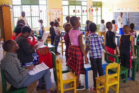Classroom in Rwanda with observers in the back as part of the Tunoze Gusoma USAID Schools & Systems Project