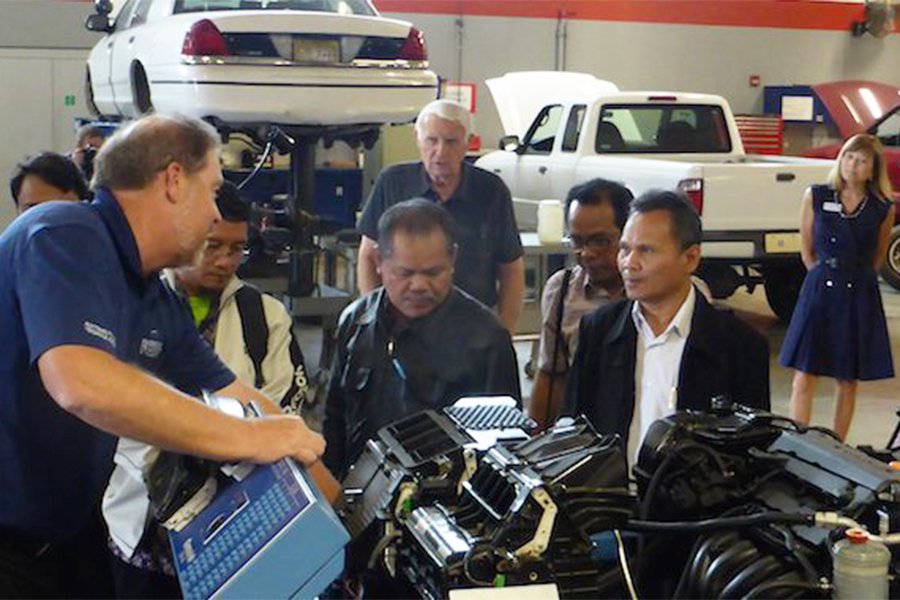"GPhoto of former LSI Director Dr. Milligan overseeing instruction to a group on auto repair at a Community College Administrator Program session"