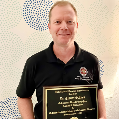 "Dr. Schoen with his teacher of the year plaque."