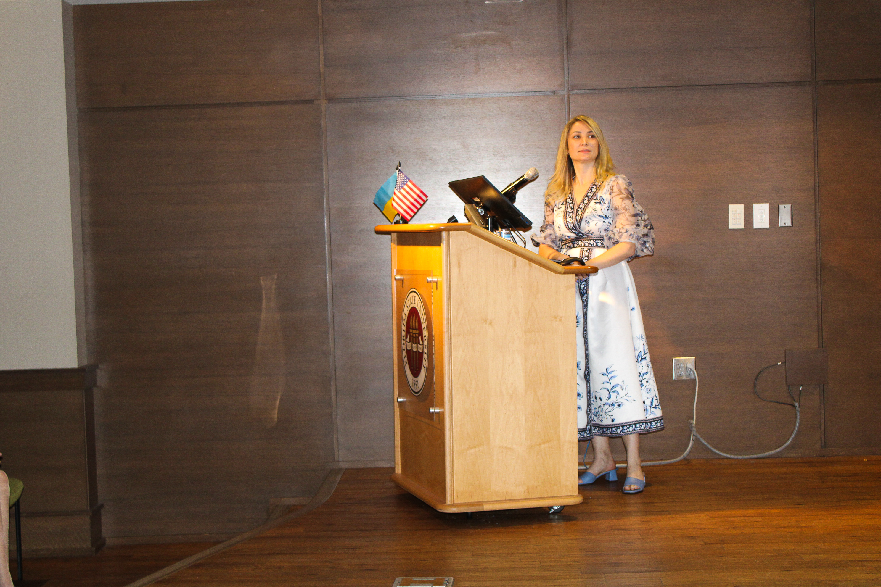"Dr. Anna Romanova standing behind a podium during a lecture"