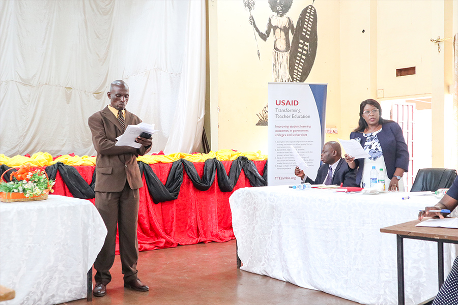 "Man at the front of a room with a microphone at a meeting for USAID TTE Zambia"