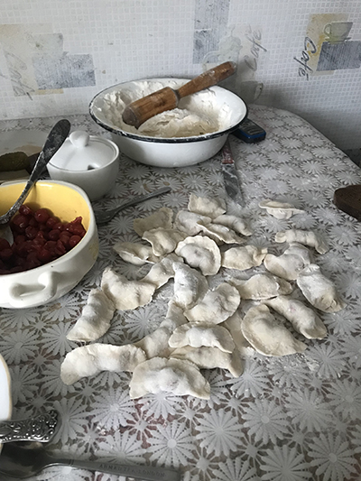 "A table with ingredients and the traditional Ukrainian food Varenyky"
