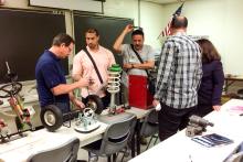 A small group in a classroom working on mechanical parts 