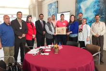 Group photo of members of the CCAP Egypt group at Santa Fe College holding a piece of artwork 