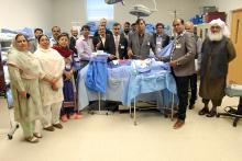 CCAP Pakistan group photo around a medical mannequin in a hospital bed  