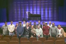CCAP Pakistan group photo in an auditorium with a piano on stage