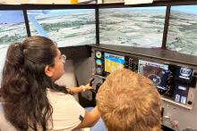 Two people sitting at a flight simulator