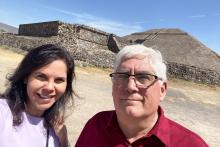 Dr. Vilma Fuentes and Dr. Jeffrey Milligan in front of ancient ruins on a trip to Mexico