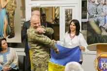 Dr. Fuentes holds the Ukrainian flag while at the ceremony for the new veterans center in Khemylnitsky, which was built as a direct result of the work of FSU's UTF.