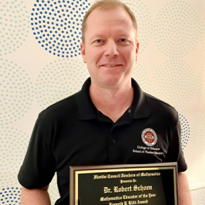 Dr. Robert Schoen poses with his  Kenneth P. Kidd Mathematics Educator of the Year plaque 