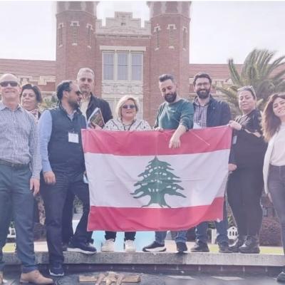 Visiting educators from Lebanon holding a Lebanese flag in front of Florida State's Westcott building. 