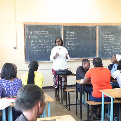 Instructor in the front of a classroom presenting to teacher trainees.