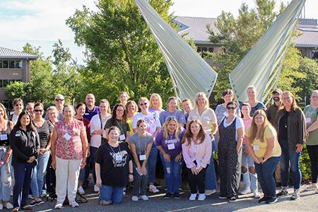 Group photo of teachers in front of a sculpture at the FSU Aero-Propulsion, Mechatronics, and Energy building. 